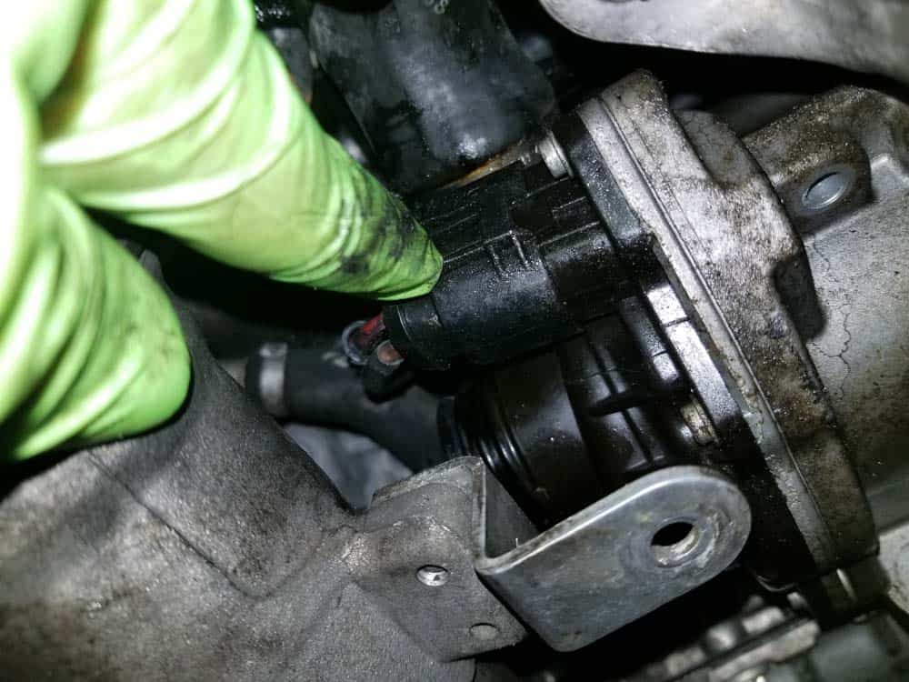 bmw e90 water pump replacement - Depress the plastic locking tab on the water pump's electrical plug