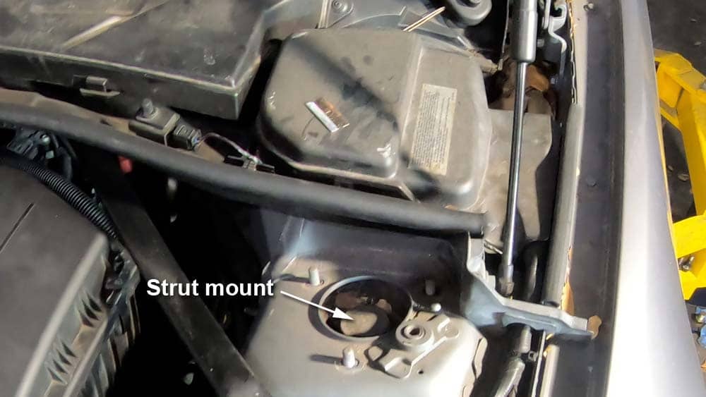 Remove the strut mount nuts with a 13mm socket wrench