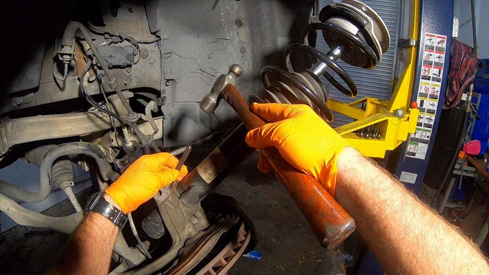 bmw e90 front strut replacement - Hammer a steel punch into the steering knuckle
