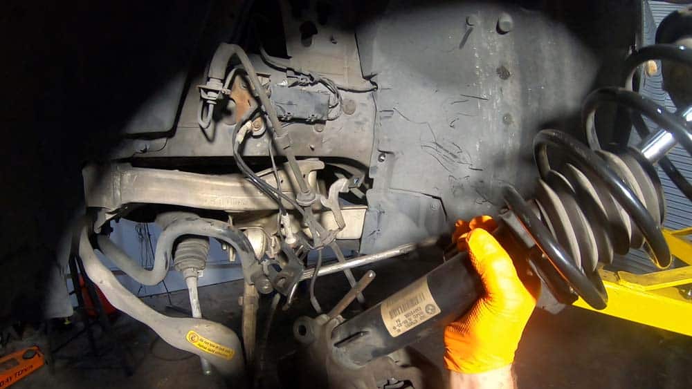 bmw e90 front strut replacement - Grasp the strut and pull it free from the steering knuckle
