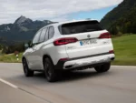 JDP_2023 BMW X5 xDrive45e White Rear Quarter View Action