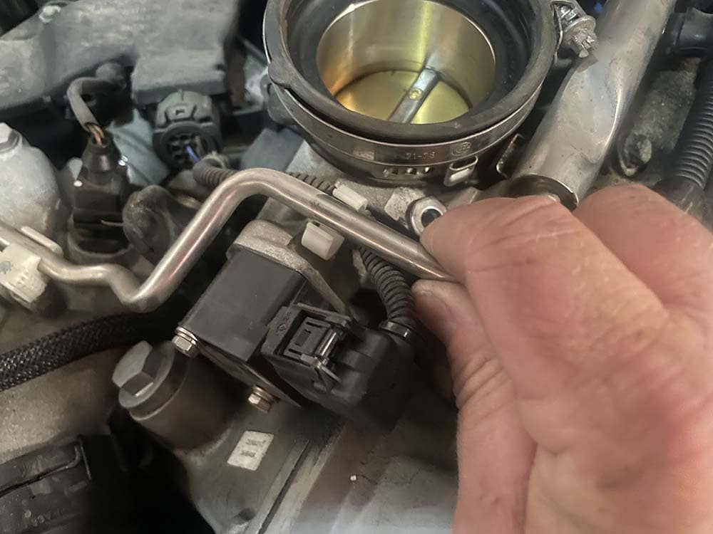 bmw e9x m3 fuel injector replacement - unsnap the injector from the metal clips